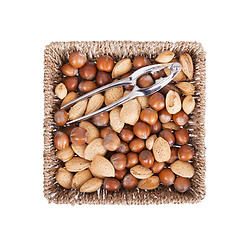 Image showing Mixed nuts in a woven basket with nut cracker