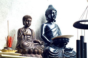 Image showing two buddhas on shelf with incense