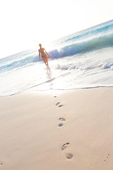 Image showing Woman running on the beach in sunset.