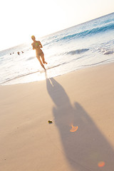 Image showing Woman running on the beach in sunset.