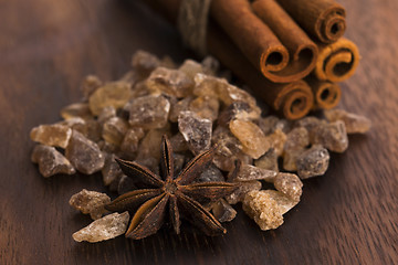 Image showing Cinnamon sticks with pure cane brown sugar on wood background