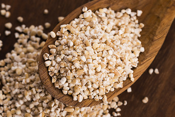 Image showing Barley groats on wooden spoon