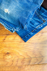 Image showing blue jeans on the wooden shelf