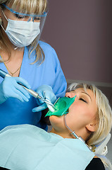 Image showing dentist with patient, using dental curing light