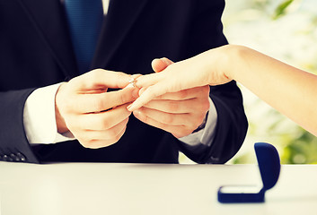 Image showing man putting  wedding ring on woman hand