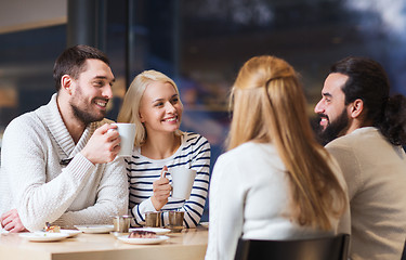 Image showing happy friends meeting and drinking tea or coffee