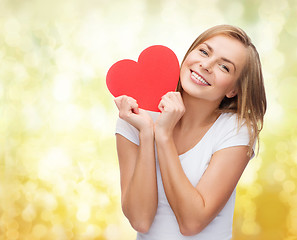 Image showing smiling woman in white t-shirt holding red heart