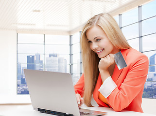 Image showing smiling woman with laptop computer and credit card