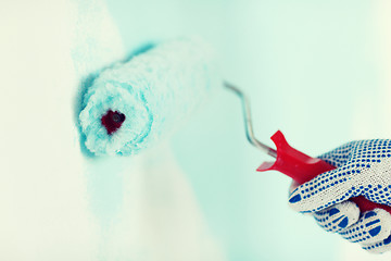 Image showing close up of male in gloves painting wall