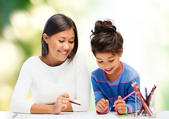 Image showing happy mother and daughter drawing with pencils