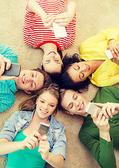 Image showing group of smiling people lying down on floor