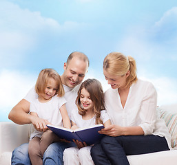 Image showing happy family with book at home