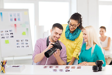 Image showing smiling team with photocamera working in office