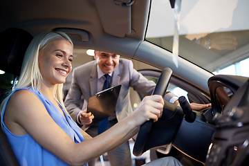 Image showing happy woman with car dealer in auto show or salon