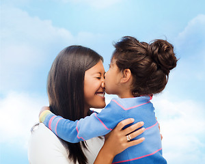 Image showing happy little girl hugging and kissing her mother