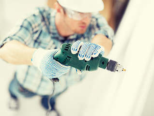 Image showing man drilling the wall