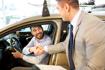 Image showing happy man with car dealer in auto show or salon