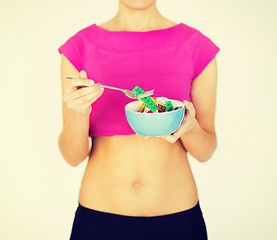 Image showing woman hands holding bowl with measuring tape