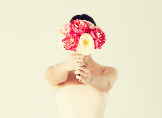 Image showing woman holding bouquet of flowers over her face