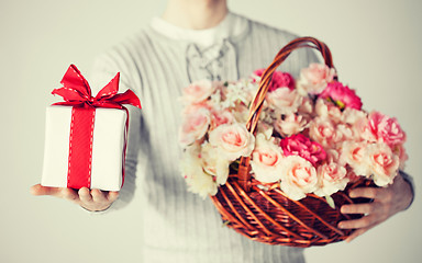 Image showing man holding basket full of flowers and gift box