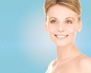 Image showing close up of smiling woman over blue background