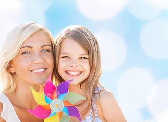 Image showing happy mother and little girl with pinwheel toy