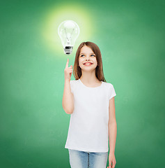 Image showing smiling school girl pointing finger to light bulb