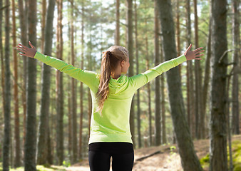 Image showing happy woman in sport clothes raising hands