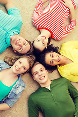 Image showing group of smiling people lying down on floor