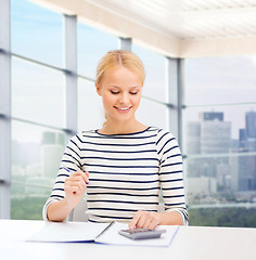 Image showing happy woman with notebook and calculator