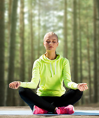 Image showing happy young woman doing yoga outdoors