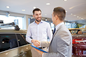 Image showing happy man shaking hands in auto show or salon