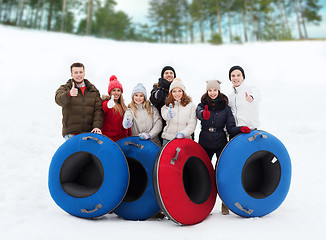 Image showing group of smiling friends with snow tubes