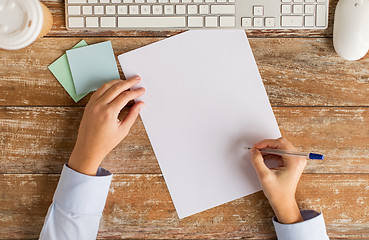 Image showing close up of hands with paper sheet and keyboard