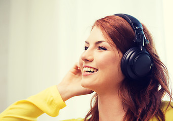 Image showing smiling young girl in headphones at home