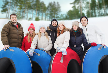 Image showing group of smiling friends with snow tubes