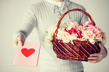 Image showing man holding basket full of flowers and postcard