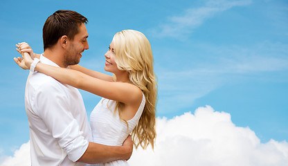 Image showing happy couple hugging over blue sky and cloud