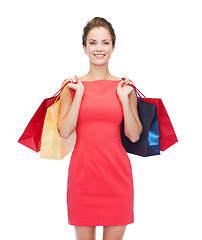 Image showing smiling elegant woman in dress with shopping bags