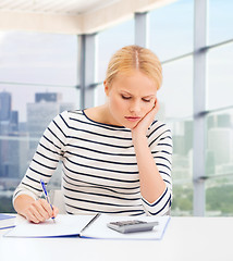 Image showing young woman with notebook and calculator