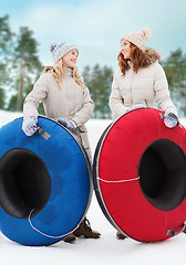 Image showing happy girl friends with snow tubes outdoors