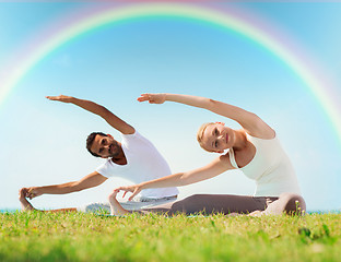 Image showing happy couple stretching and doing yoga exercises