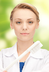 Image showing happy young female dentist with tooth brush