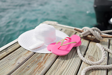 Image showing close up of hat, sunscreen and slippers at seaside