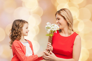 Image showing happy little daughter giving flowers to her mother