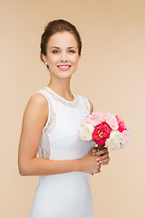 Image showing smiling woman in white dress with bouquet of roses