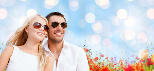 Image showing happy couple in shades over poppy field background