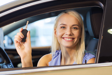 Image showing happy woman getting car key in auto show or salon