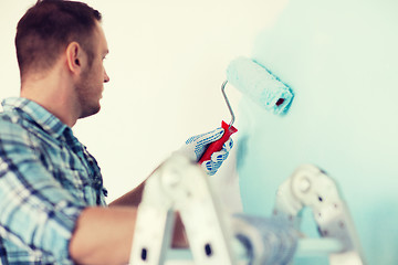 Image showing close up of male in gloves holding painting roller