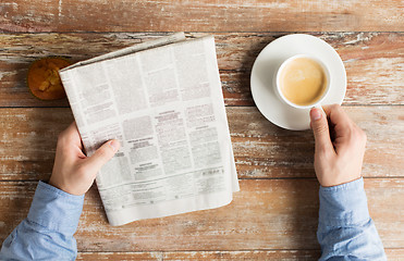 Image showing close up of male hands with newspaper and coffee